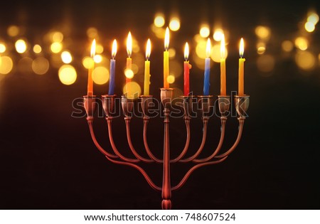 image of jewish holiday Hanukkah background with menorah (traditional candelabra) and burning candles. glitter overlay