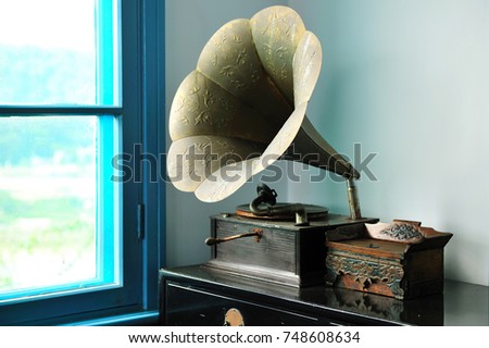 The gramophone next to the window plays nostalgic songs
