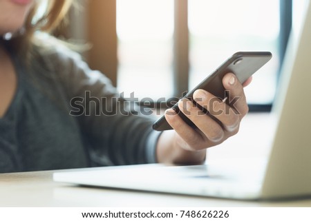 woman use phone on desk in office place