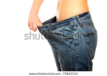 A picture of a young slim woman in oversized pair of blue jeans over white background