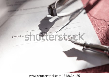Close-up of Contract form with fountain pen and glasses