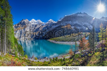 Amazing tourquise Oeschinnensee with waterfalls, wooden chalet and Swiss Alps, Berner Oberland, Switzerland. Royalty-Free Stock Photo #748660981