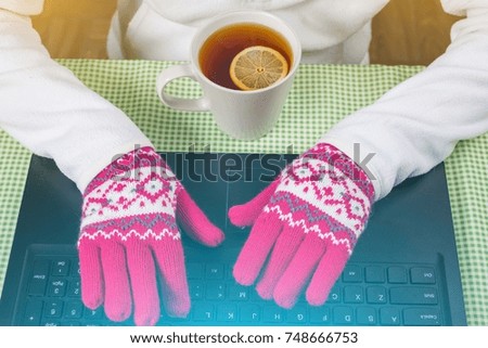 Winter background - picture, laptop, gloves, sweater, hot tea.