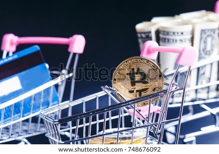 Bitcoin, bank card and money in a trolley on a black background. Concept of shopping and money. Cryptocurrency. Online shopping. Virtual currency and business.