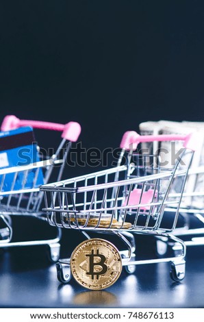 Bitcoin, bank card and money in a trolley on a black background. Concept of shopping and money. Cryptocurrency. Online shopping. Virtual currency and business.