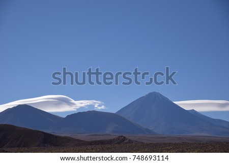 Chilean volcanoes with clouds. Royalty-Free Stock Photo #748693114