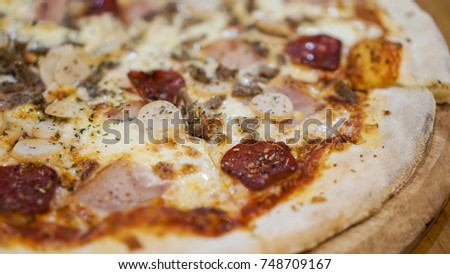 Slice of hot pizza large cheese lunch or dinner crust with meat topping sauce. Delicious tasty fast food italian traditional on wooden board table classic in side view with bokeh background.