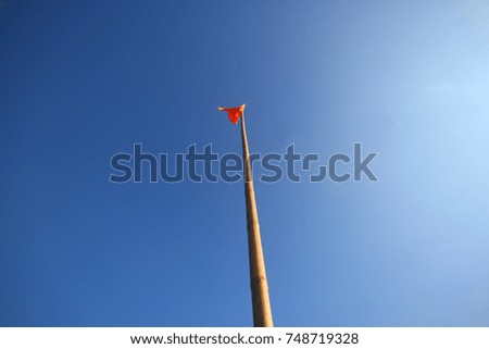 Waving red flag on blue sky background
