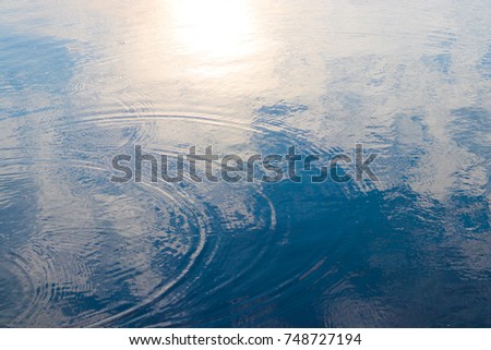 Water wave with reflection of clouds and sunset scene
