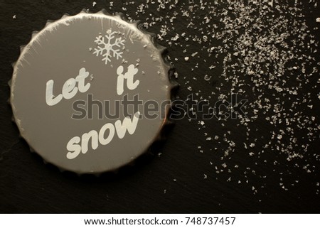 Grey beer coaster for decoration with artificial snowflakes on black background
