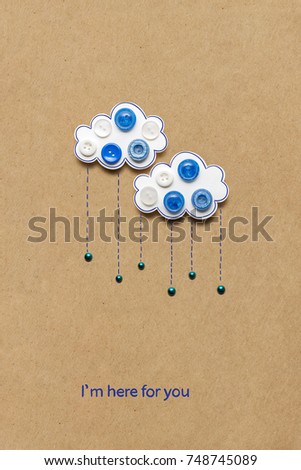 Creative concept photo of an clouds with buttons made of paper on brown background.