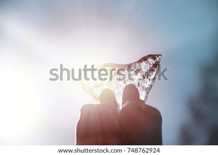 Romantic concept, ice heart in the hands with sunlight, Valentine's day