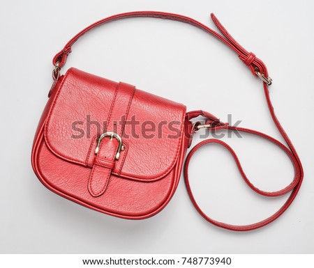 Red leather bag on a white background. Fashionable women's accessories. Top view. Royalty-Free Stock Photo #748773940
