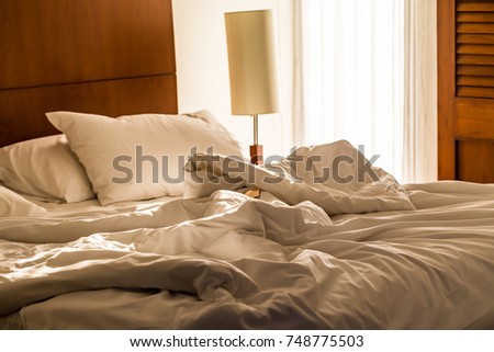 unmade bed in morning sunlight. Royalty-Free Stock Photo #748775503