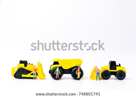 Under construction concept, with group of human toy and heavy duty machinery vehicle on white background with copy space for mocup your product.