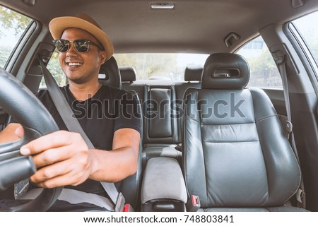 Young handsome asian man driving car to travel. Royalty-Free Stock Photo #748803841