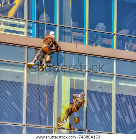 Spiderman washing Windows in high-rise building