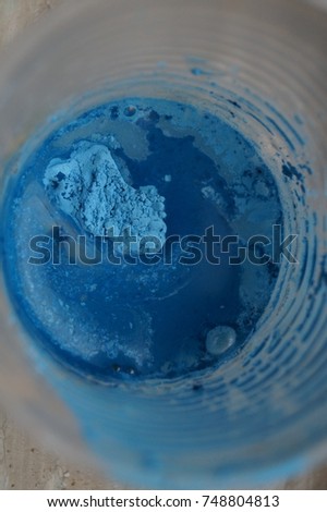 Blue pigment mixing with water. Paint preparation