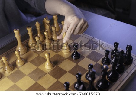 The debut of the chess game. The hand with Bishops makes a move on chess Board