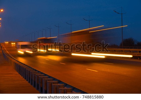 Highway traffic cars at night blured. Cars moving on road on bridge evening blurry.