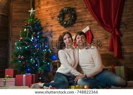 couple man and woman, husband and wife celebrate Christmas in a decorated home with a Christmas tree