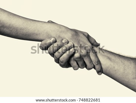 Concept of salvation. Black and white image of the hands of two people at the time of rescue (help). Royalty-Free Stock Photo #748822681