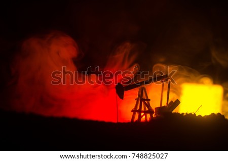 Oil pump oil rig energy industrial machine for petroleum, Group oil rigs and brightly lit industrial site at night. Toned.Background for design. Selective focus