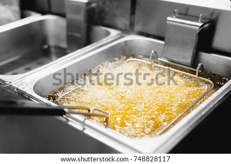 Fryer with French fries, close-up. The oil boils Royalty-Free Stock Photo #748828117
