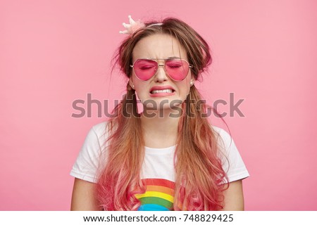 Desperate coquette woman going to cry, has sorrorful expression, regrets her actions, makes big mistake or failure, frowns face. Miserable female poses in pink studio, expresses negative emotions Royalty-Free Stock Photo #748829425