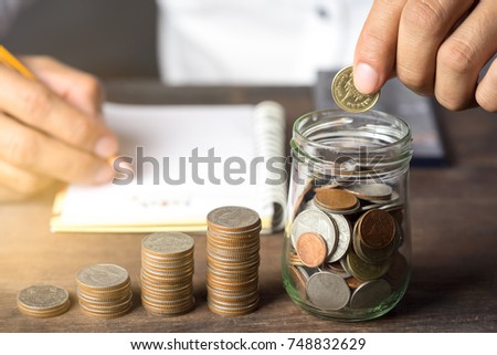 Financial Accounting Concepts with Businessman putting coins in glass and saving money.