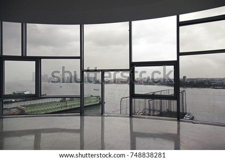 An interior of an apartment and a view of river and city skyline