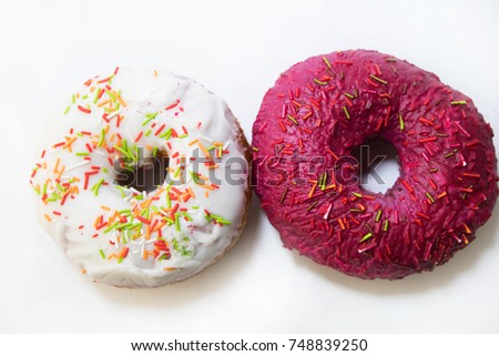 two donuts  covered with red glaze top view on white background