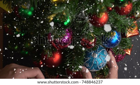 Greeting Season concept.hand setting of ornaments on a Christmas tree with decorative light