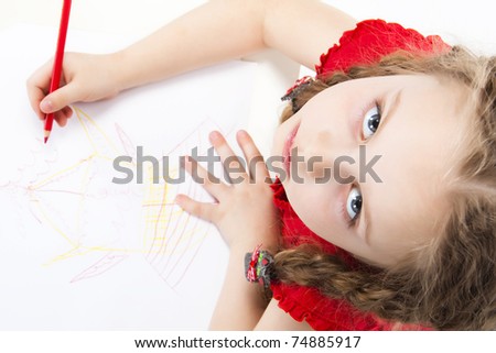 little girl with pigtails draws with crayons