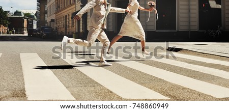 asian bridal couple running across the street, happy wedding, bride and groom together Royalty-Free Stock Photo #748860949