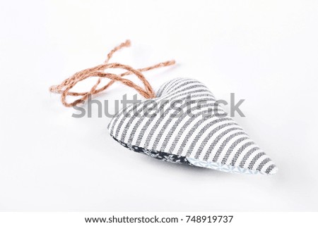 White striped handmade textile heart. Textile handicraft isolated on white background. Gift on Valentine day.