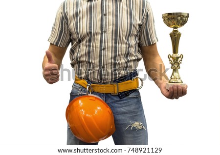 Builder construction worker in mounting belt and with helmet holding in hands golden cup award trophy. Awards ceremony. Best builder worker of the year. Success in construction and repair.