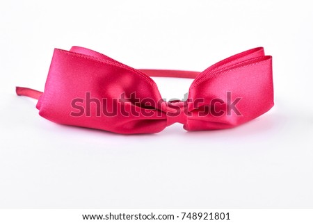 Pink hair band with bow. Beautiful pink head hoop isolated on white background. Kids hair accessory on sale.