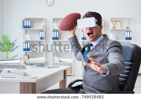 Businessman playing virtual reality football in office with VR g