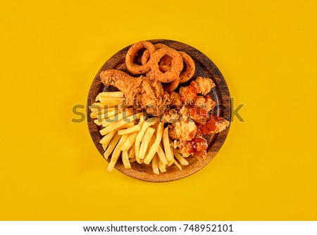 Fast food dish on yellow background. Fast food set fried chicken and french fries. Take away fast food. Royalty-Free Stock Photo #748952101