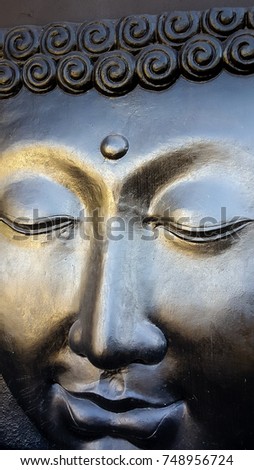 Face of buddha in reflective grey paint