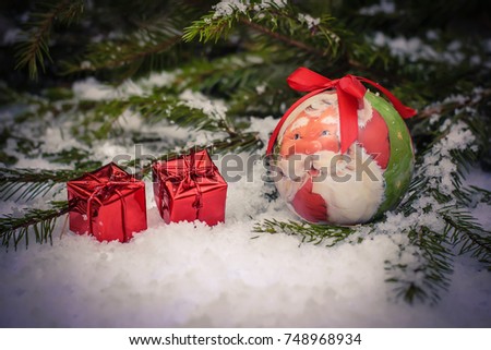 Wonderful winter picture with Santa in Christmas ball and gifts in shiny red boxes with gifts