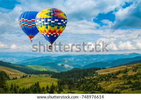 Colorful hot-air balloons flying over the mountains. Artistic picture. Beauty world