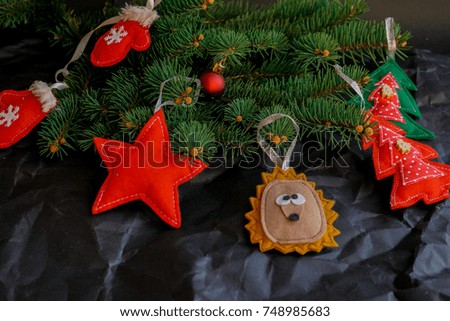 nature tree fir branch decorated with handmade toys from felt on black crafted background