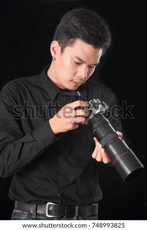 Young male photographer in studio to pay close attention to take a photo ( camera vintage )