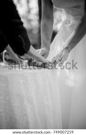 hands of the newlyweds, close-up, candle. Black and white photo