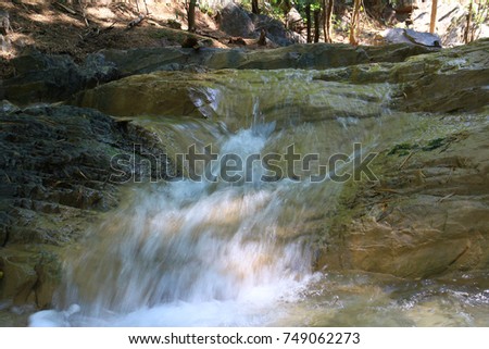 Rocks with clear water streams and small waterfalls green forest background and some images are similar but different shutter speeds