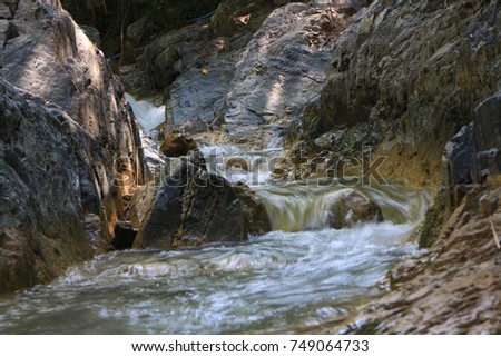 Rocks with clear water streams and small waterfalls green forest background and some images are similar but different shutter speeds