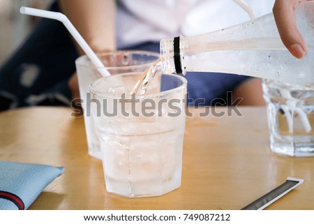 Pouring drinking water into a glass on the table