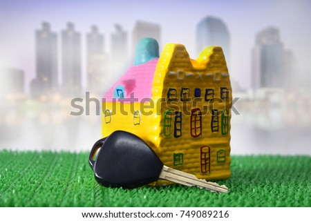 House with Old Car key on green artificial turf for property real estate investment concept. 